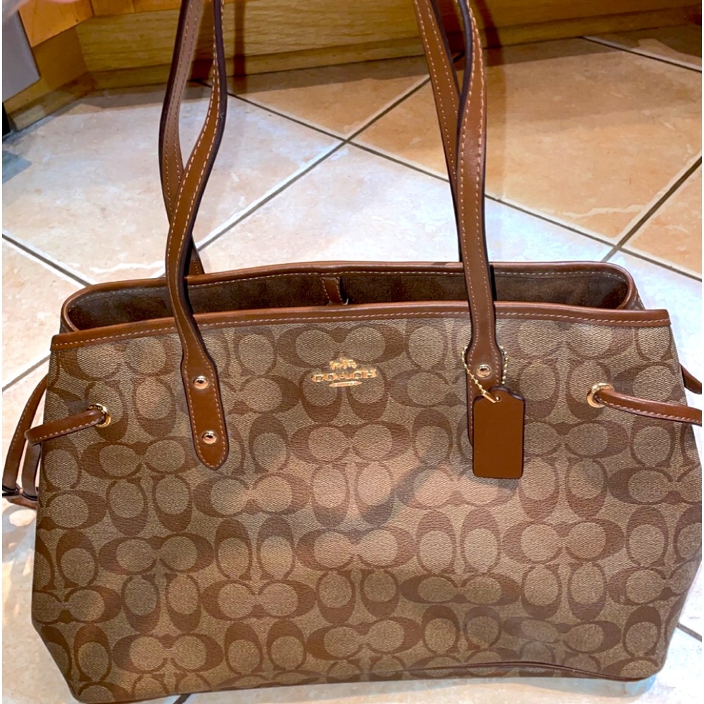 BNWOT Never used brown Coach leather purse with gold hardware.